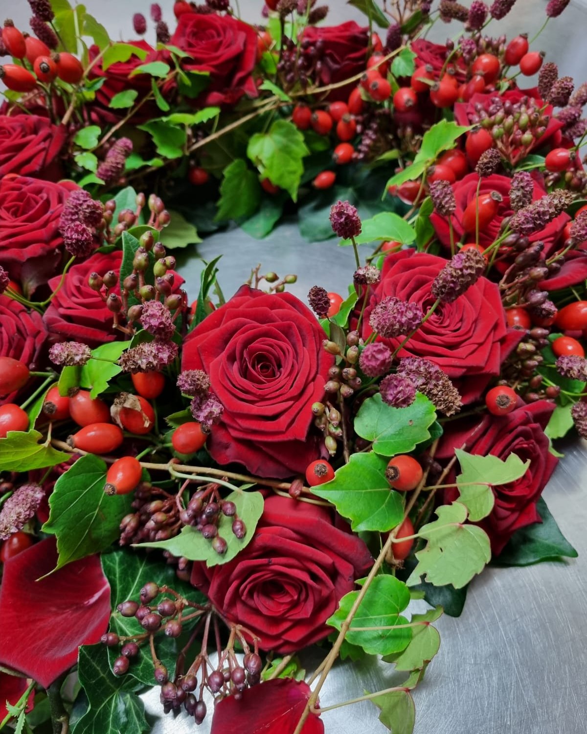 Ein Kranz mit besonderer Form.
Tiefrote Rosen, Efeu und Hagebutten werden durch einen locker fallenden Schweif ergänzt und ergeben ein ausdrucksstarkes Gesamtbild. 
Entstanden in unserer Filiale in der Donnersbergstraße. 🌿

#kochchristmann #kaiserslautern #floristik #kranz #rosen #blumenhandwerk #floristikhandwerk